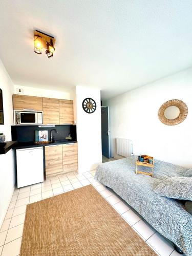 une chambre avec un grand lit et une cuisine dans l'établissement Cocon marin - Parking - Proche mer, à La Grande Motte