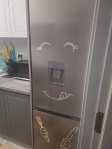 a refrigerator in a kitchen with drawings on it at Adrian's room in Dudu