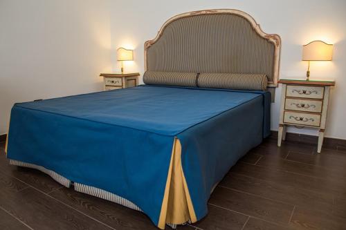 a large blue bed with a blue blanket on it at La Rada B&B in Bacoli