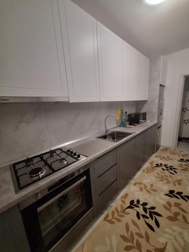a kitchen with white cabinets and a stove top oven at Adrian's room in Dudu