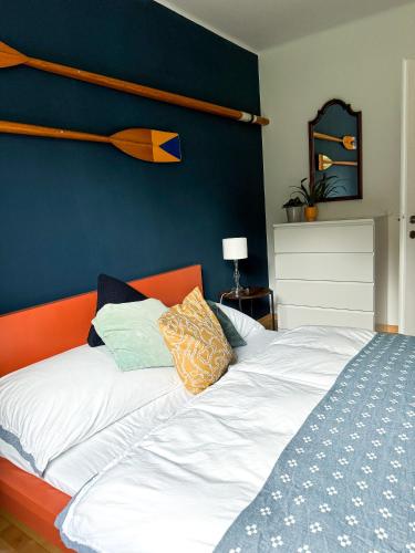a bed with an orange headboard and pillows on it at Lake Life in Sankt Gilgen