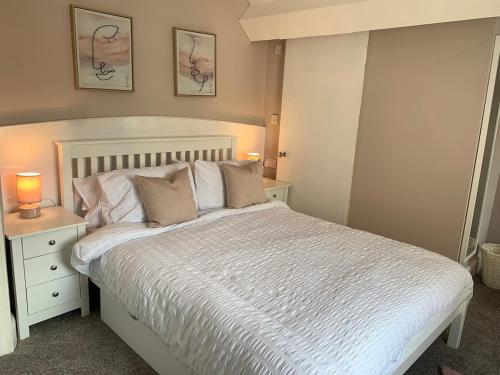 a bedroom with a white bed with two lamps on it at Tara Lodge #19 in Llandudno