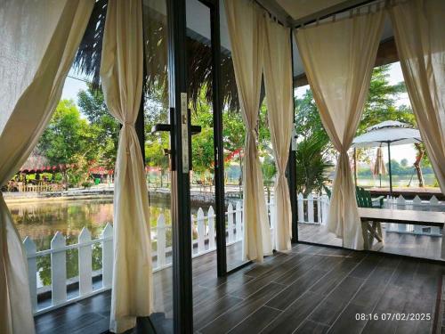 porche con puertas de cristal y vistas al agua en Homestay Mẹ khang 2 - Room lake view, en Cu Chi
