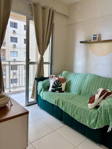 a living room with a green couch and a window at Desativado in São Luís