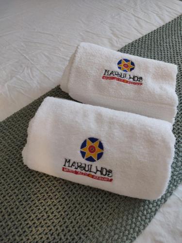 two towels on a bed with the words happy kop at Marulhos Resort Studio Master in Porto De Galinhas