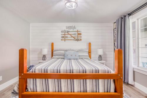 a bedroom with a bed with a striped bedspread at Heron Cove - Meredith Lodging in Otis