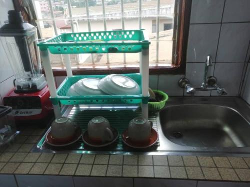 una cucina con una mensola con i piatti e un lavandino di studio meublé essos a Yaoundé
