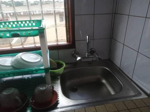 un lavello da cucina con un rubinetto e una finestra di studio meublé essos a Yaoundé
