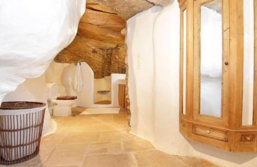 a bathroom with a toilet and a wooden cabinet at Aegean Bliss Villa - Hydroussa in Andros