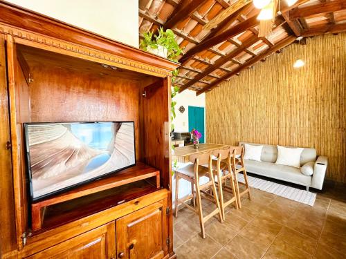 a living room with a tv and a table at CABO BOHEMIA Tropical Garden Studios in Cabo San Lucas