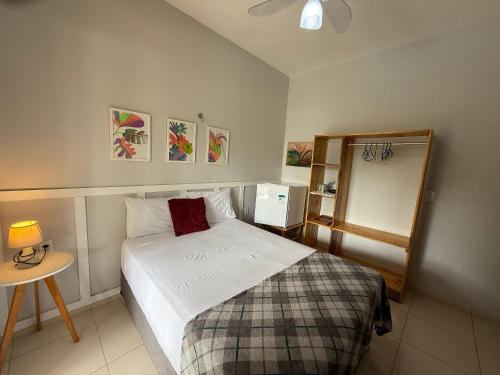 ein kleines Schlafzimmer mit einem Bett und einem Tisch in der Unterkunft Hosts BR - La Serena Suíte Cumbuco in Cumbuco