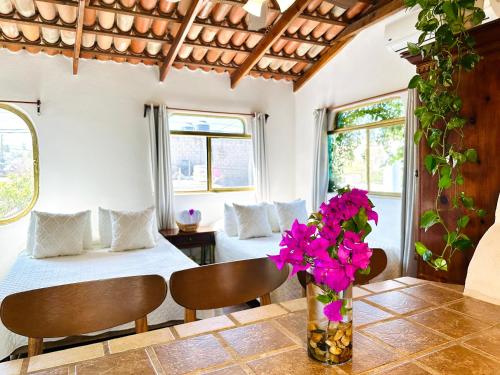a room with a bed and a table with flowers at CABO BOHEMIA Tropical Garden Studios in Cabo San Lucas