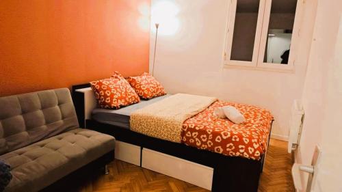 une petite pièce avec un lit et une chaise dans l'établissement Mini-studio avec kitchenette OU chambre confort avec frigo et TV - Parking en option sur résa !, à Chaville