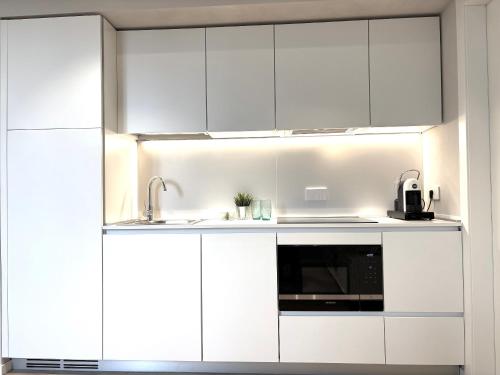 a kitchen with white cabinets and a sink at Palazzo Betteloni in Bardolino
