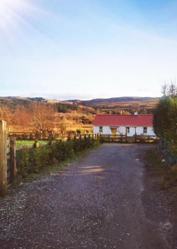 a white house with a red roof and a driveway at The Red Bridge Cottage in Glenties