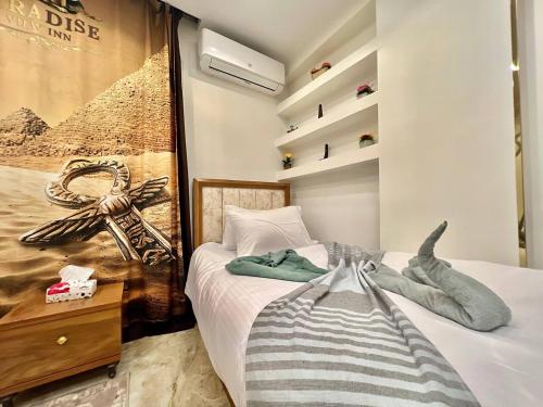 - une chambre avec un lit et une affiche murale dans l'établissement Paradise Pyramids View INN, au Caire
