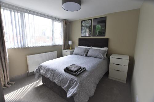 a bedroom with a large bed and a window at Central Cheerful Comfortable 3 Bedroom Home in Pallion