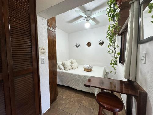a bedroom with a bed with a table and a ceiling fan at CABO BOHEMIA Tropical Garden Studios in Cabo San Lucas
