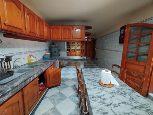 a kitchen with wooden cabinets and a tile floor at Saidia Plage in Saidia 