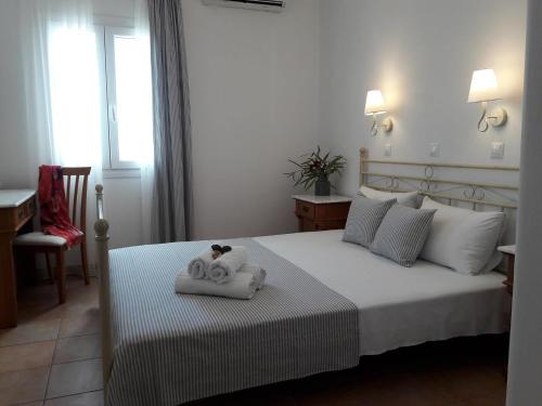 a bedroom with a bed with two towels on it at Stavento Apartments in Aliki