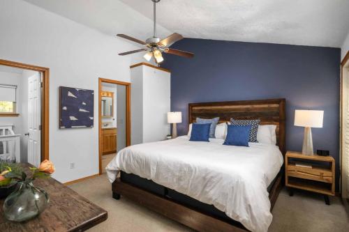 a bedroom with a bed with blue walls and a ceiling fan at Dogwood Villa in Dundee