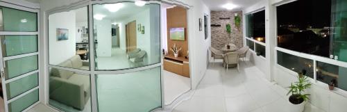 a hallway with a glass door and a living room at FLAT Maré Alta - Porto de Galinhas in Porto De Galinhas