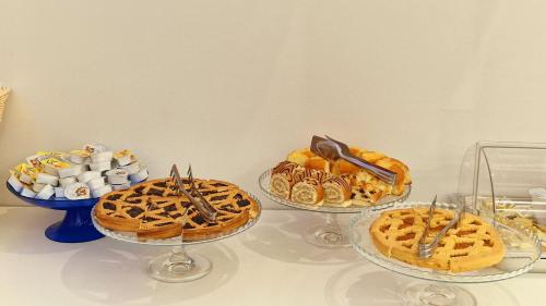 three plates of waffles and other desserts on a table at Hotel Firenze 2000 in Florence