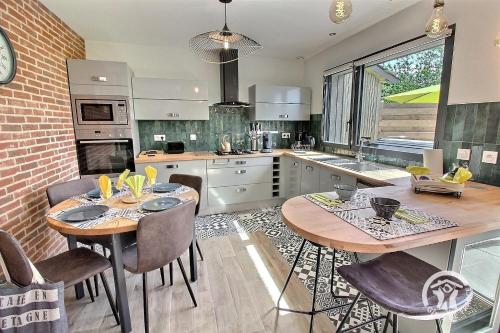 une cuisine avec deux tables et des chaises dans l'établissement Grange nature, à Les Champs-Géraux