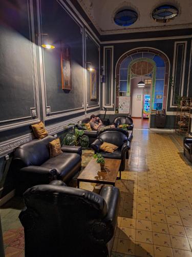 a living room with leather couches and a table at Hostel Alvear in Cordoba