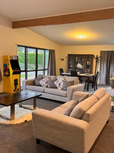 a living room with two couches and a table at Woodbank Retreat in Hanmer Springs