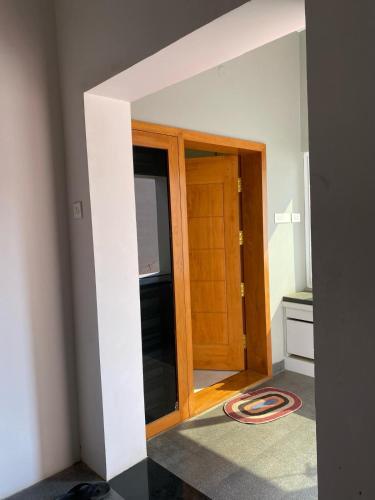 a room with a wooden door in a room at Vidhyashree Illam in Madurai