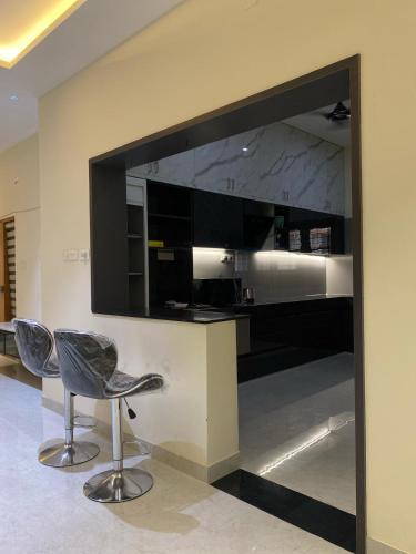a kitchen with two chairs and a large television at Vidhyashree Illam in Madurai