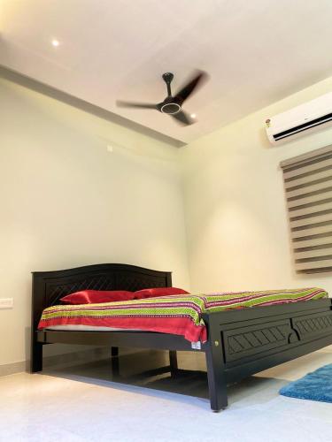 a bedroom with a bed and a ceiling fan at Vidhyashree Illam in Madurai