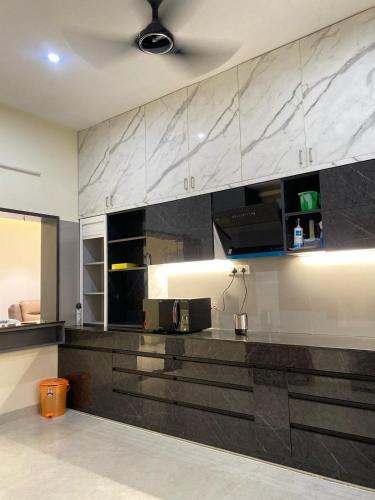 a kitchen with black and white marble counter tops at Vidhyashree Illam in Madurai