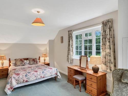 a bedroom with a bed and a desk and a window at Wey House Withypool in Withypool