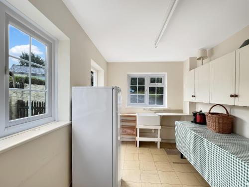 a kitchen with a refrigerator and a window at Wey House Withypool in Withypool