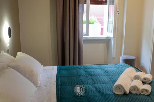 a bedroom with a bed with towels and a window at Palazzo Giudecca in Reggio Calabria