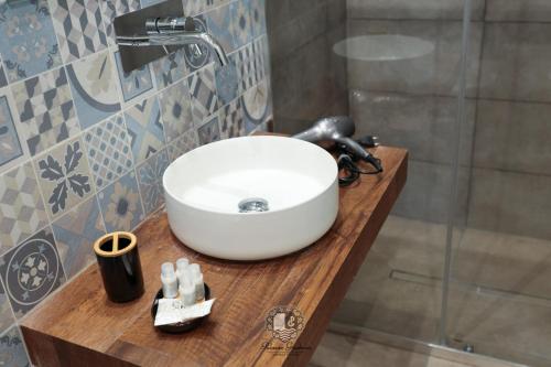 a bathroom with a white sink on a wooden counter at Palazzo Giudecca in Reggio Calabria