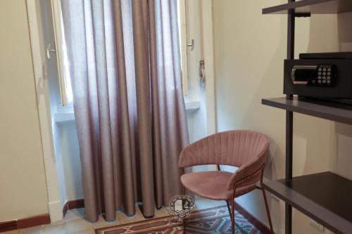 a chair sitting in front of a window with a curtain at Palazzo Giudecca in Reggio Calabria