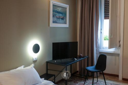 a hotel room with a desk and a bed and a window at Palazzo Giudecca in Reggio Calabria