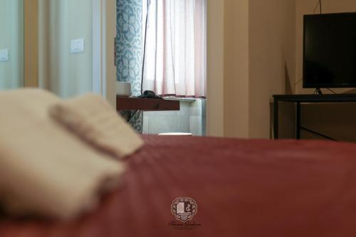 a hotel room with a bed and a television at Palazzo Giudecca in Reggio Calabria