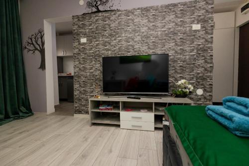 a living room with a flat screen tv on a brick wall at Urban Escape Arad in Arad