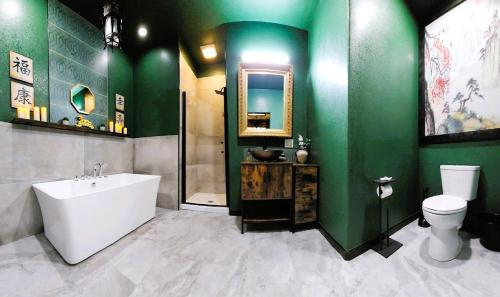 a bathroom with a white tub and green walls at Asian Zen Den in Sparks
