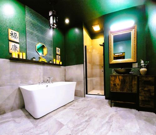 a bathroom with a tub and a sink and a mirror at Asian Zen Den in Sparks