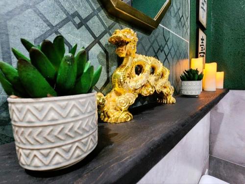 a gold lion statue sitting on a counter next to a potted plant at Asian Zen Den in Sparks