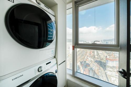 a washer and dryer in a room with a window at Brown Suites Busan Station in Busan