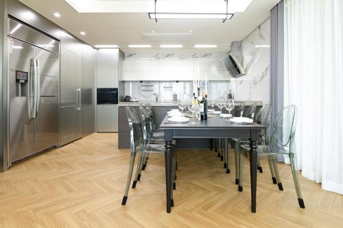 a kitchen and dining room with a black table and chairs at Brown Suites Busan Station in Busan