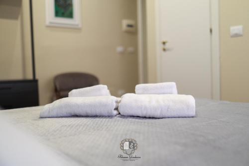 two stacks of towels sitting on top of a bed at Palazzo Giudecca in Reggio Calabria