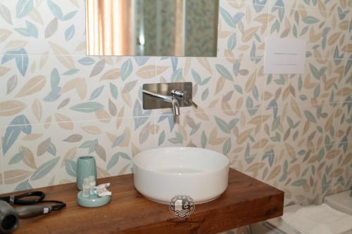 a bathroom with a white sink on a wooden counter at Palazzo Giudecca in Reggio Calabria