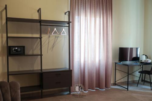a room with a book shelf and a desk with a window at Palazzo Giudecca in Reggio Calabria